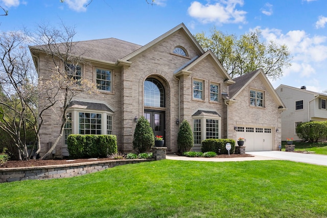 traditional-style house with a garage, driveway, brick siding, and a front yard
