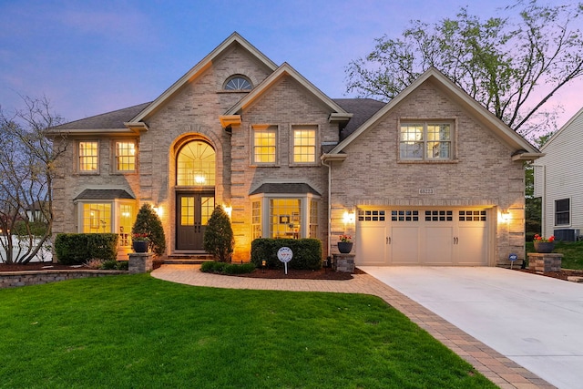 view of front facade with a garage, a yard, concrete driveway, and brick siding