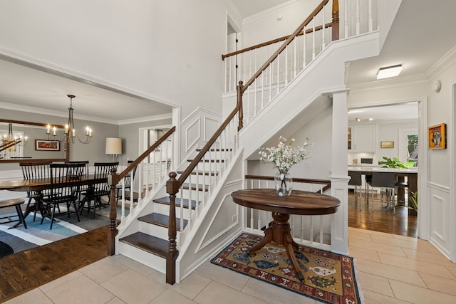 stairway featuring crown molding, tile patterned floors, and a high ceiling
