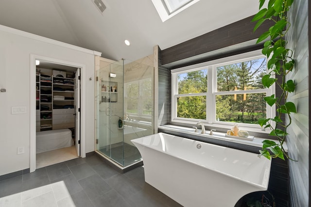 bathroom featuring visible vents, a walk in closet, tile patterned floors, vaulted ceiling with skylight, and a shower stall