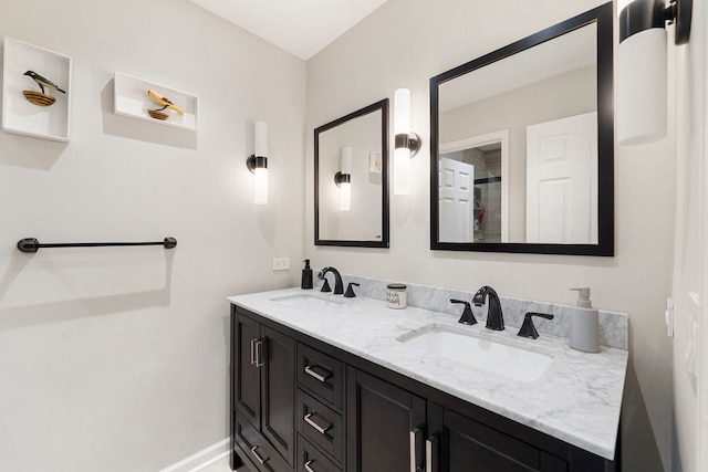 bathroom with a sink, baseboards, and double vanity