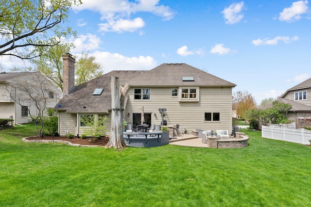 back of house with a lawn, fence, a patio, and a chimney