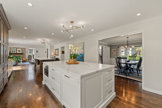 kitchen with an inviting chandelier, a healthy amount of sunlight, and a center island