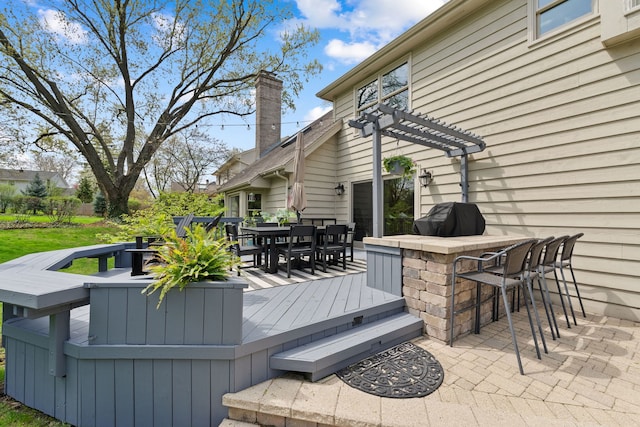 deck featuring outdoor dry bar, a pergola, outdoor dining area, and a grill