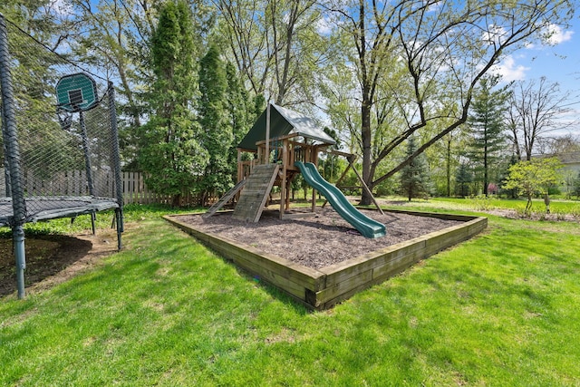 community jungle gym with a lawn, fence, and a trampoline