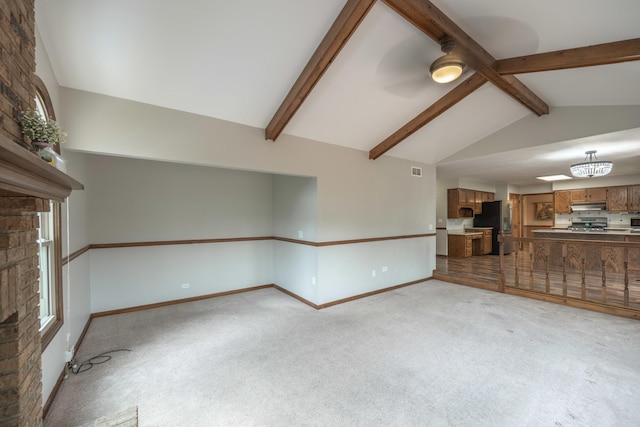 unfurnished living room with baseboards, light colored carpet, lofted ceiling with beams, and visible vents