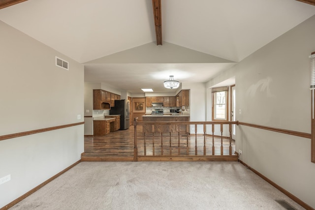 carpeted living room featuring visible vents, lofted ceiling with beams, and baseboards