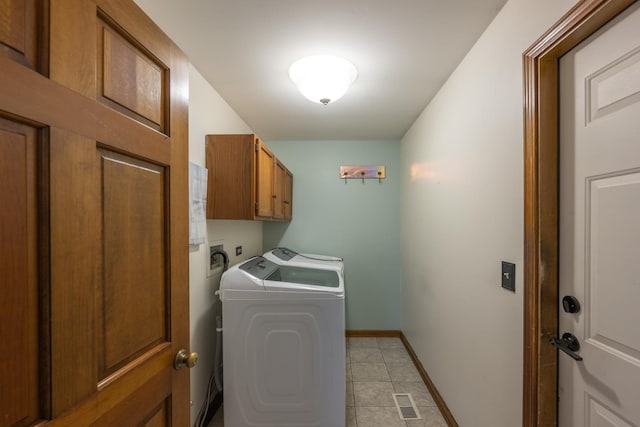 clothes washing area with visible vents, washing machine and clothes dryer, cabinet space, baseboards, and light tile patterned flooring