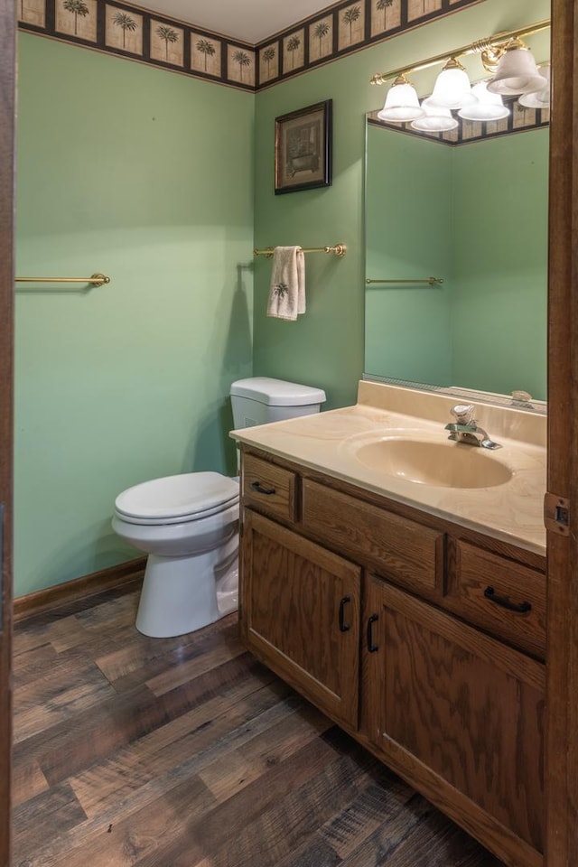 bathroom with toilet, wood finished floors, and vanity