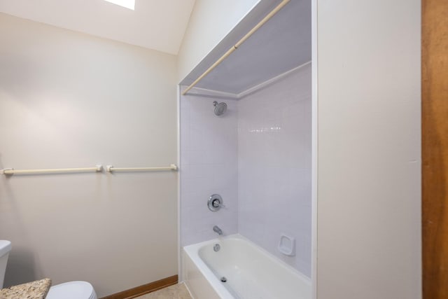 bathroom with toilet, baseboards, vaulted ceiling, and bathtub / shower combination