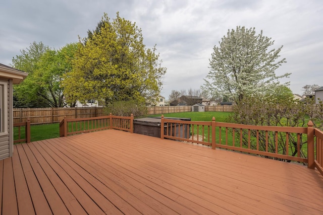 wooden deck with a storage shed, an outdoor structure, a yard, and a fenced backyard