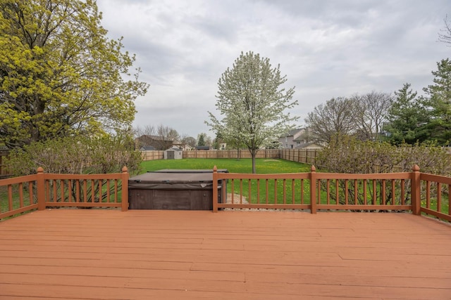 wooden terrace featuring a fenced backyard, a yard, and a hot tub