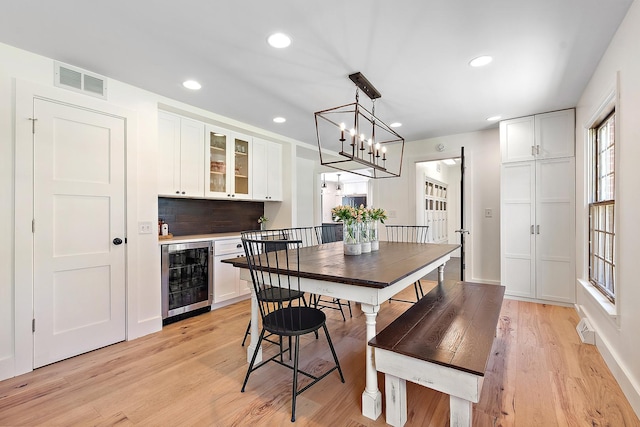 506 Aberdeen Rd, Frankfort, IL 60423 - dining space with wine cooler, a dry bar, light wood-type flooring, a chandelier, and recessed lighting