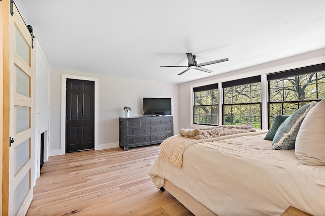 506 Aberdeen Rd, Frankfort, IL 60423 - bedroom with light wood-type flooring, a barn door, baseboards, and a ceiling fan