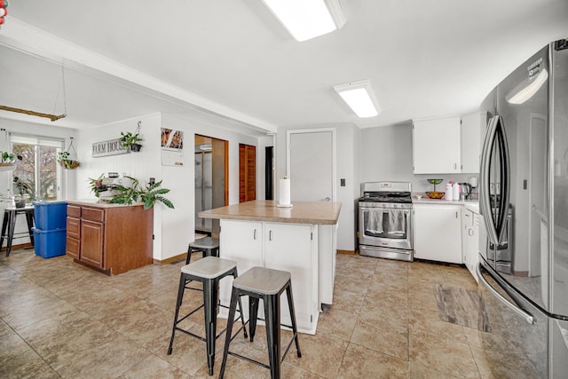 824 Rowlett Ave, Melrose Park, IL 60164 - kitchen featuring white cabinets, a center island, light countertops, appliances with stainless steel finishes, and a breakfast bar