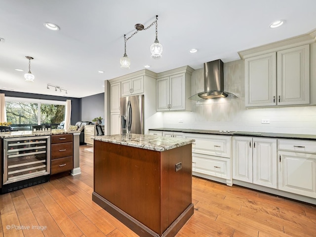 kitchen with tasteful backsplash, hanging light fixtures, stainless steel fridge with ice dispenser, wall chimney exhaust hood, and wine cooler