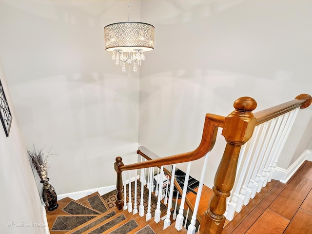 stairs featuring a notable chandelier and baseboards