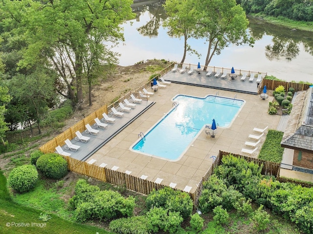 community pool with fence, stairway, a water view, and a patio