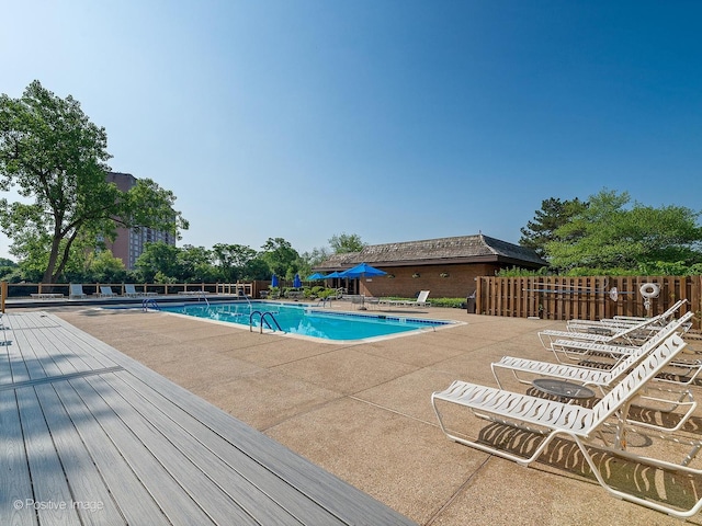 community pool featuring fence and a patio