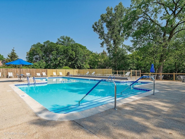 pool featuring fence and a patio area