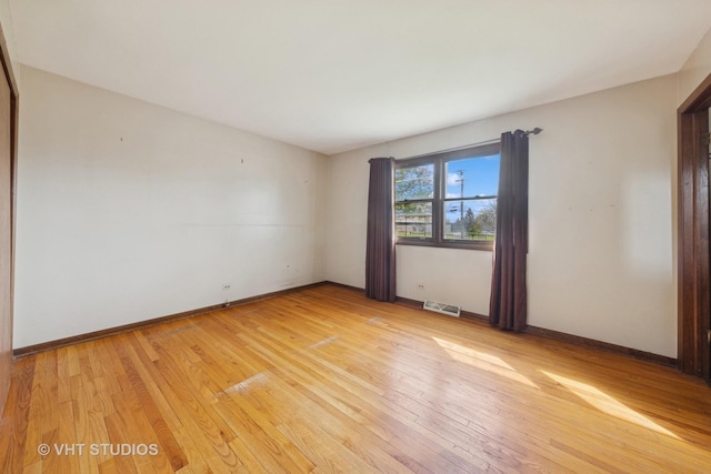 unfurnished bedroom featuring a closet, light wood finished floors, baseboards, and visible vents
