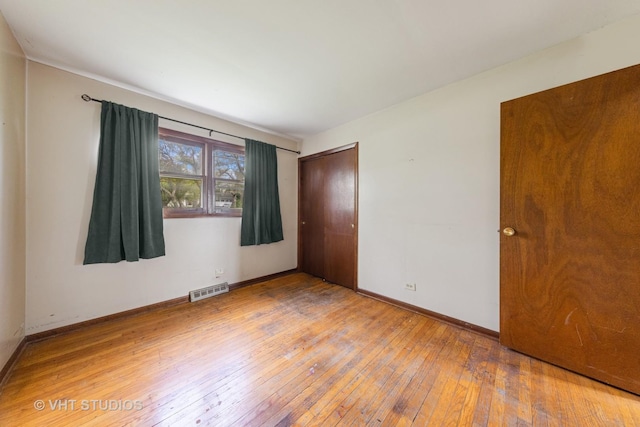 interior space featuring light wood-style floors, baseboards, and visible vents