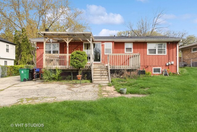 view of front of property featuring board and batten siding, central AC unit, a deck, and a front lawn