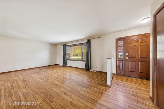 unfurnished living room featuring baseboards, light wood-type flooring, and visible vents