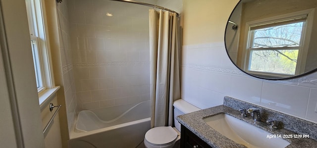 bathroom with tile walls, toilet, vanity, and shower / bathtub combination with curtain