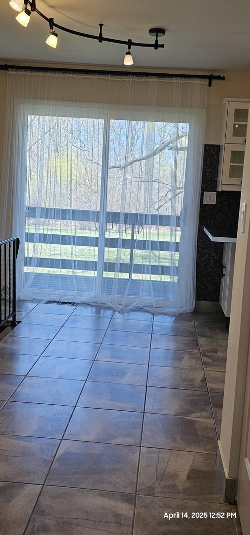 unfurnished dining area featuring tile patterned flooring