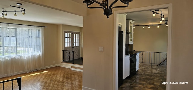 interior space featuring an upstairs landing, baseboards, and rail lighting
