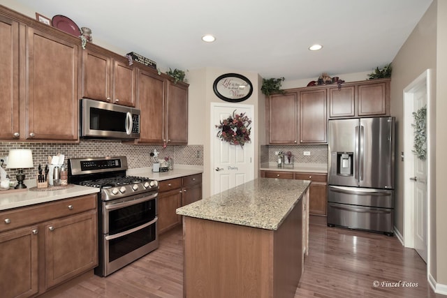 459 E Amberside Dr, Elgin, IL 60124 - kitchen with appliances with stainless steel finishes, wood finished floors, tasteful backsplash, a kitchen island, and recessed lighting