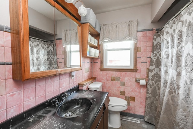 full bath featuring tasteful backsplash, vanity, toilet, visible vents, and tile walls