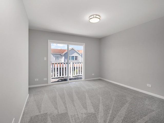 carpeted empty room featuring baseboards
