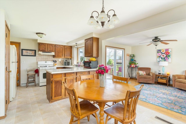 dining room with ceiling fan with notable chandelier and visible vents