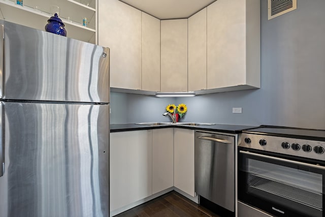 3660 N Lake Shore Dr Unit 711, Chicago, IL 60613 - kitchen featuring dark wood finished floors, dark countertops, stainless steel appliances, and a sink