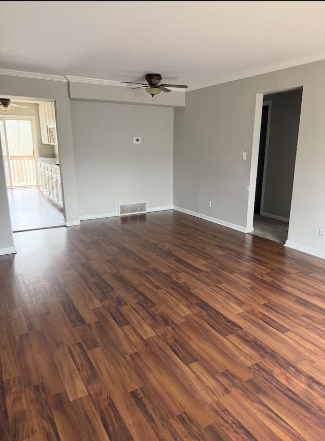 unfurnished room with crown molding, ceiling fan, visible vents, dark wood-style flooring, and baseboards