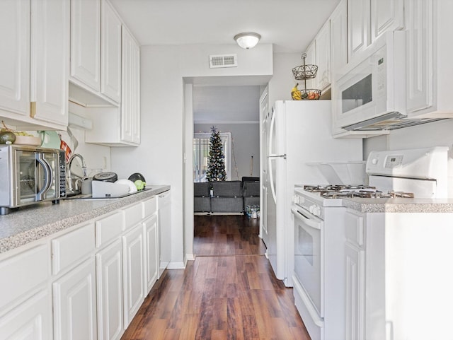 kitchen with white appliances, visible vents, dark wood-style flooring, and white cabinetry