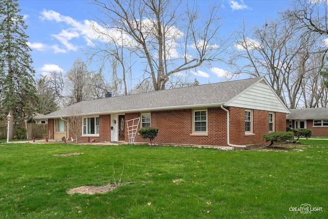 ranch-style house with brick siding, a shingled roof, a front lawn, and fence