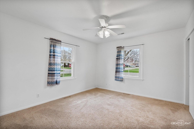 unfurnished bedroom featuring carpet floors, visible vents, a ceiling fan, and baseboards