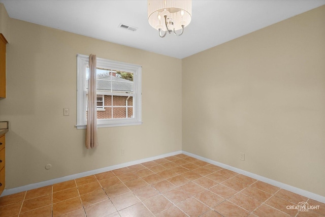empty room with baseboards, visible vents, a notable chandelier, and light tile patterned flooring