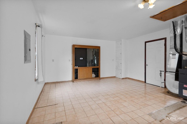 spare room with electric panel, baseboards, and light tile patterned floors
