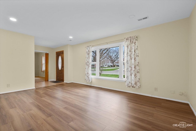 unfurnished living room featuring baseboards, wood finished floors, visible vents, and recessed lighting