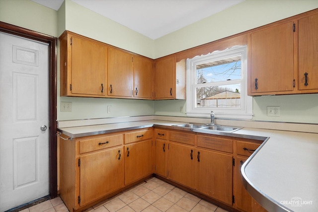 kitchen featuring light countertops, a sink, and light tile patterned flooring