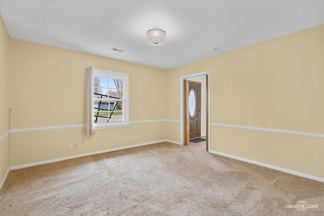 carpeted empty room featuring baseboards and visible vents