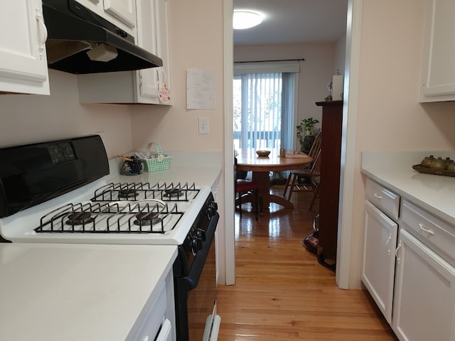 kitchen featuring light wood-type flooring, white cabinetry, gas range, light countertops, and under cabinet range hood