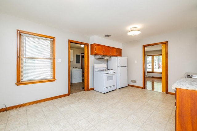 kitchen featuring visible vents, washer / dryer, white appliances, baseboards, and light countertops