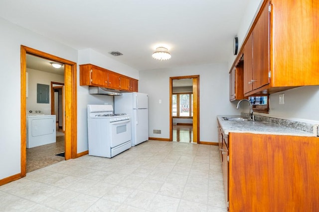 kitchen with washer / dryer, white appliances, light countertops, electric panel, and a sink