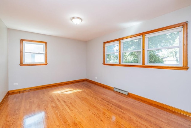 unfurnished room featuring light wood-style floors, baseboards, and plenty of natural light