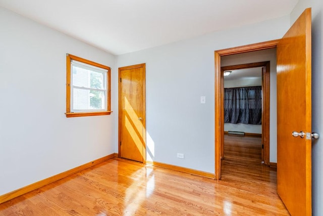 spare room featuring light wood-style floors and baseboards